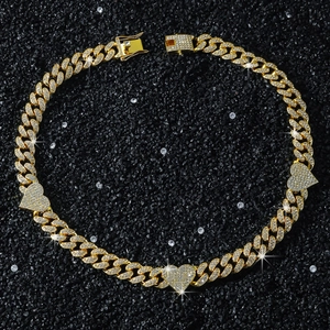 Detail of 13mm gold Cuban link chain with iced-out heart pendants in hip hop style