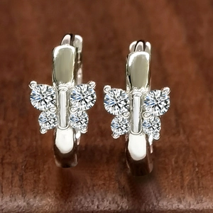 S925 sterling silver butterfly hoop earrings with sparkling cubic zirconia on wood background