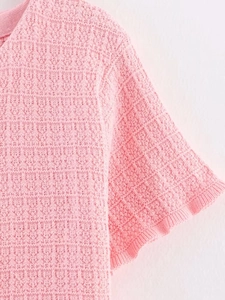 Detailed view of pink knitted fabric texture and shoulder stitching on a casual top
