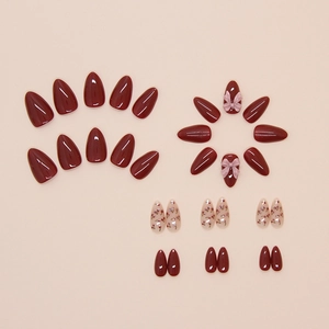 Detailed set of almond-shaped press-on nails with dark red colors and 3D bow accents