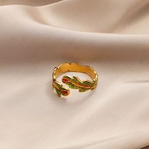 Detail of leaf-shaped open ring with green and orange enamel on silk background
