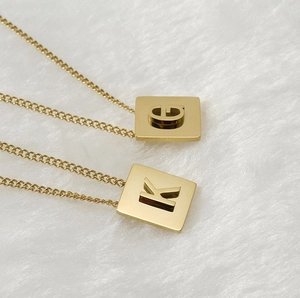 Detail of square 18K gold plated stainless steel necklaces with hollow G and K letters