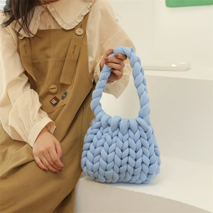 Handmade blue chunky yarn knitted tote bag held by a model in casual outfit