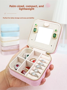 Close-up of portable pink velvet jewelry box with mirror and ring slots for travel