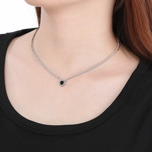 Close-up of a silver necklace featuring a black heart pendant with inlaid zircon stones