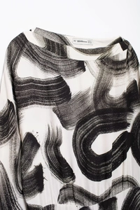 Detailed view of the brand collar label on a zen-style ink print round neck dress