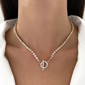 Detail van gouden tennisketting met fonkelende zirkonia en een stijlvolle toggle-sluiting
