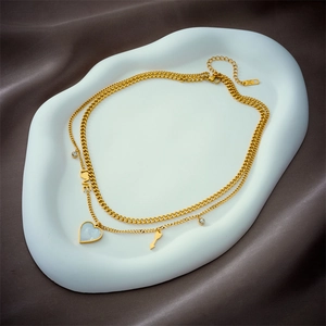 Double-layered gold necklace featuring LOVE letter heart pendant and arrow charm with zircons