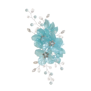Macro detail of bridal hair clip with turquoise resin flowers and crystal bead accents