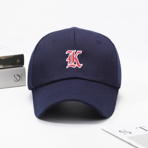 Navy blue baseball cap with red embroidered K letter and curved brim for sun protection