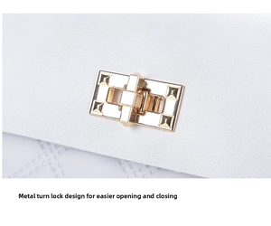 Detailed macro view of white leather handbag featuring a golden pyramid stud twist lock