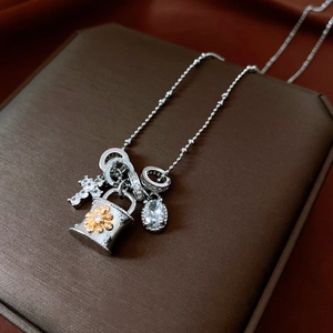 Detail of cross and bucket charms on a beaded necklace with sparkling zircons