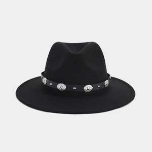 Detalle del sombrero de fieltro negro con tachuelas plateadas y hebilla de metal grabada