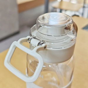 Detail of white lid and square carrying handle on 600ml plastic sports water bottle