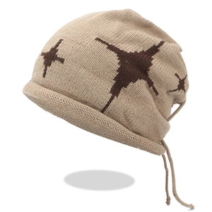 Macro detail of beige knit beanie showing star pattern texture and braided drawstrings