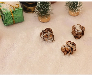 Close-up of three miniature pine cones with artificial snow in a Christmas scene