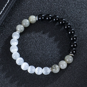 Detailed view of 8mm moonstone and obsidian beads on elastic bracelet with silver spacers