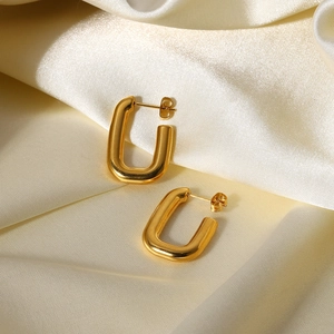 Polished 18K gold-plated stainless steel U-shaped earrings on elegant silk background