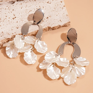 Detailed macro view of silver U-shaped tassel earrings with white acrylic flower petals