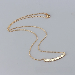 Detail of gold chain necklace with hexagonal zircon pendants and a lobster clasp