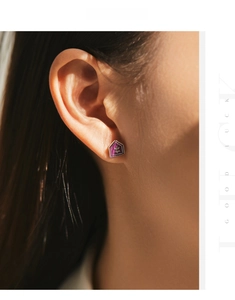 Detailed view of s925 silver earring with purple enamel floral badge on model ear