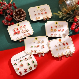 Detailed view of Christmas earring set with Santa, reindeer and tree designs on card