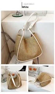 Detail of summer straw tote bag featuring white leather trim and metal rivet accents