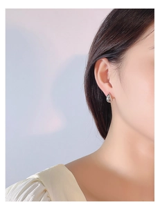Close-up of elegant S925 sterling silver waterdrop stud earrings worn by a model