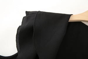 Détail de l'épaule à volants noirs sur un haut sans manches ou une robe en mousseline