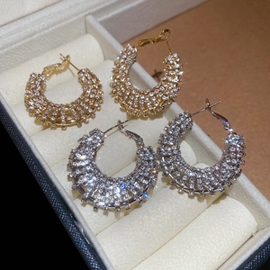 Sparkling pavé crystal hoop earrings in gold and silver finish displayed in a box