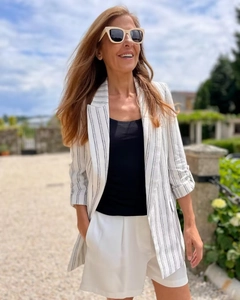 Close-up of white striped blazer with rolled sleeves and breathable texture for women
