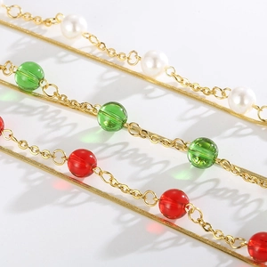 Close-up of golden dual-layer bracelet with pearls and colorful glass beads details
