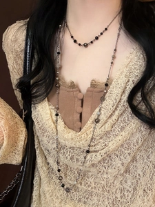 Close-up of layered double-strand necklace featuring silver flowers and crystal beads