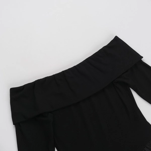 Detailed close-up of black ribbed knit fabric with an elegant off-the-shoulder neckline