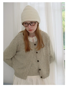 Detail of oatmeal knit wool blend cardigan and matching vest set for women winter
