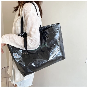 Close-up of a glossy black large-capacity tote bag with green Beautifully text