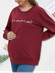Detail of burgundy maternity sweatshirt featuring white Mama script and heart print