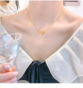 Close-up of 18k gold plated double heart necklace with sparkling crystals on a model