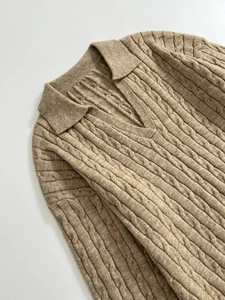 Detail of camel cable knit texture on a V-neck Polo sweater with classic ribbed patterns
