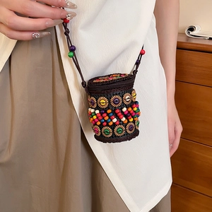 Detail of colorful beads and circle buckle on ethnic woven crossbody bag for women