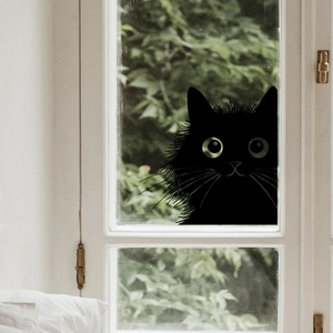 Detailed view of a black peeking cat window decal on glass with a garden background