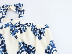 Close-up of blue and white tie-dye halter neck with bow tie detail on a vacation dress