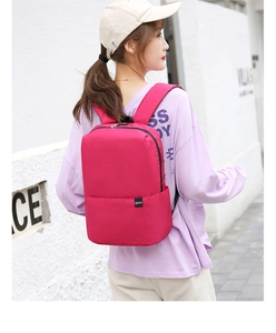 Outdoor street shot of a rose red lightweight backpack on model showing size and fit