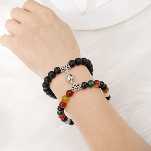 Close-up of magnetic couples bracelets with matte black beads and colorful natural stones
