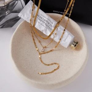 18K gold stainless steel layered necklace with teardrop zircon pendant in a ceramic bowl