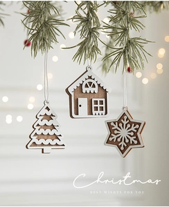 Detailed view of wooden Christmas ornaments with snowflake and house shapes on pine branch