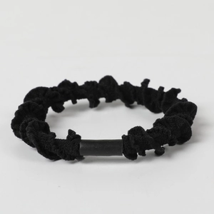 Detail showing the pleated fabric texture and durable connector of the black hair tie