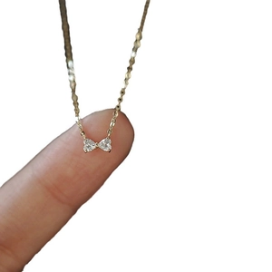 Mini S925 silver bow pendant necklace in 14K gold with heart-shaped white zircons
