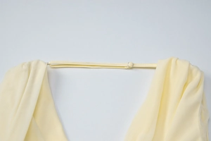 Detail view of adjustable straps and soft knitted fabric texture in pale yellow