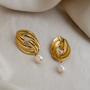 Detailed view of 18K gold plated twisted earrings with white freshwater pearl on silk